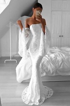 a woman is taking a selfie in her wedding dress while standing on the floor