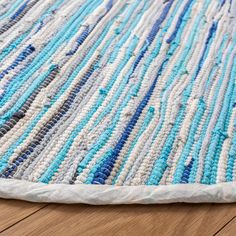 a blue and white rug is laying on the floor next to a wooden flooring