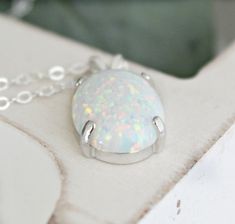 "Beautiful Large white lab-created opal pendant necklace. These gorgeous opals are very similar to natural mined opals. Lab-created opals contain 70-90% silica (from which natural opal is formed) and 10-30% resin. The resin makes the opal harder, stronger, unlike natural opals, which are known to be soft and fragile. Each opal displays a rainbow of color that sparkles with every catch of light. I've handset two different size opals in a solid sterling silver prong settings 16x12mm (5/8\" x 1/2\" White Ethiopian Opal Gemstone Jewelry, White Oval Opal Necklace, White Opal Round Pendant Necklace, White Opal Necklace For Gift, White Ethiopian Opal Gemstone Necklace, White Ethiopian Opal Cabochon Jewelry, White Opal Pendant Jewelry, White Opal Gemstone Necklace, White Opal Cabochon Necklaces