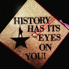 a graduation cap with the words history has its eyes on you in black and gold glitter