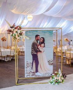 an image of a newly married couple in front of a wedding photo