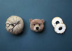 three balls of yarn, two teddy bears and one ball of yarn are arranged on a blue surface