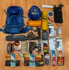 an assortment of hiking gear laid out on a wooden floor next to it's contents