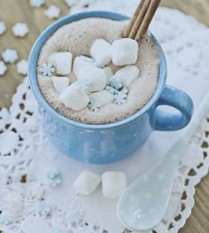 a cup filled with hot chocolate and marshmallows on top of a table