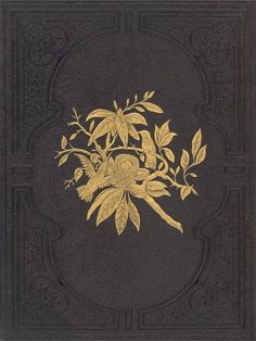 an old book with gold flowers and leaves on the cover, sitting on a black surface