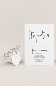 a white card with the words let's party on it next to some flowers