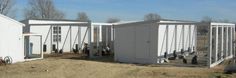 two white buildings sitting next to each other on top of a dry grass covered field