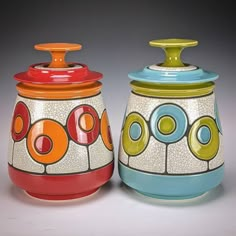 two ceramic containers with colorful designs on them