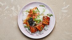 a white plate topped with tofu and rice