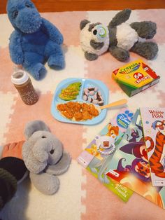 stuffed animals and children's food on a blanket