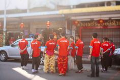 a group of people in red shirts standing on the street