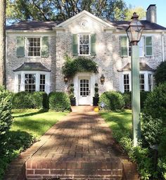 a large brick house surrounded by trees and bushes