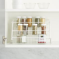 an organized spice rack in a white kitchen