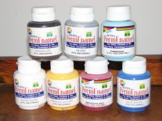 several bottles of paint sitting on top of a wooden table