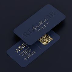 two dark blue business cards with gold foil on the front and back, sitting side by side