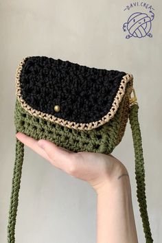 a hand holding a crocheted purse in it's palm, with the bottom flap open