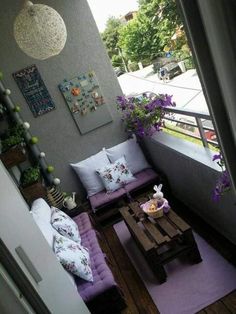 a living room filled with furniture and lots of purple flowers on top of the couches