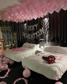 two beds in a room with balloons and streamers