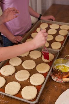 two women are making homemade cookies on a table