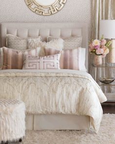 a bedroom with a large mirror above the headboard and pillows on the bed in front of it