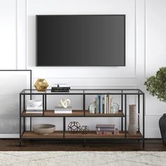 a living room with a large television mounted on the wall and bookshelf in front of it