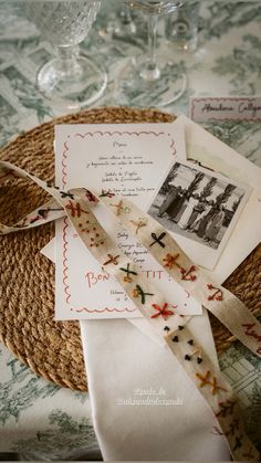 an old photo and some ribbons on a table with wine glasses in the back ground