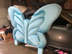 a blue butterfly shaped chair sitting on top of a car