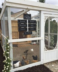 several chickens in a small white coop with a sign on it that says the farm