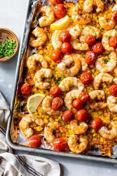 a sheet pan filled with shrimp and tomatoes