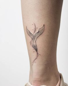 a woman's leg with a small tattoo on the back of her leg, and a whale tail