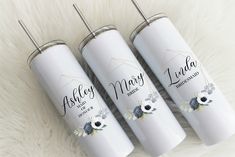 three personalized travel mugs sitting on top of a white furnishing floor