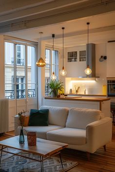 a living room filled with furniture next to a window covered in light fixturees and windows