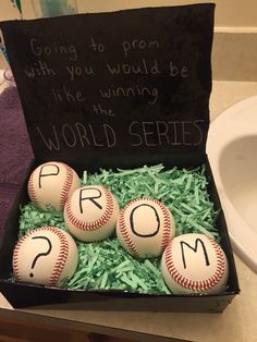 four baseballs in a box with the word prom written on them