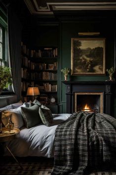 a bedroom with dark green walls and a fireplace in the corner is lit by two lamps on either side of the bed