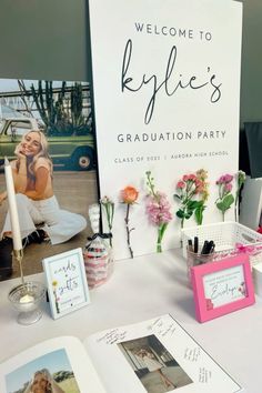 a table topped with pictures and flowers next to a sign that reads welcome to kylie's graduation party