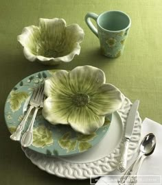 an image of a table setting with flowers on the plate and silver utensils