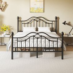 a black metal bed frame in a room with white carpeting and two side tables