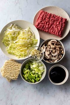 bowls filled with different types of food sitting on top of a white marble countertop