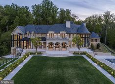 an aerial view of a large house with a pool and landscaping in the foreground