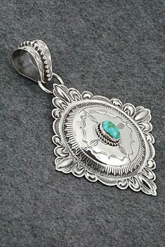 This stunning Sonoran Gold turquoise and sterling silver pendant was made by Navajo silversmith Roland Dixon. The back is signed Roland Dixon and stamped sterling.Length: 5 1/2"Width: 4 1/8"Free shipping on all orders! We ship with USPS and always include tracking. All orders ship within a day of payment.Returns are accepted up to 30 days after you receive your order. Just send us a message. Our shop offers cash back or store credit. The item must be returned in new condition. Traditional Silver Turquoise Concho Necklace, Western Style Silver Turquoise Necklace With Large Pendant, Traditional Silver Turquoise Necklace With Concho, Engraved Silver Southwestern Turquoise Necklace, Engraved Silver Turquoise Necklace In Southwestern Style, Southwestern Sterling Silver Turquoise Concho Necklace, Native American Jewelry, Turquoise Sterling Silver, Sterling Silver Pendant