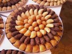 several trays filled with different types of pastries on top of a white table