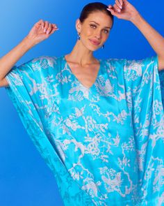 A most elegant statement kaftan that exudes quiet opulence. Silver birds nestle amongst cherry blossom branches against a backdrop of rich, turquoise blue. Crafted from beautifully draping silk, our Ava Silk Kaftan has a sheen that highlights the flutter of every movement.Hand-crafted of the softest, beautifully draping washable silk. Washable silk is 100% silk. It is more durable than regular silk as it is made using a special construction technique so that it can better handle the harsh moveme Blue Silk V-neck Kaftan, Elegant Blue Floral Print Kimono, Elegant Blue Floral Print Kaftan, Blue Silk Kaftan For Spring, Spring Blue Silk Kaftan, Blue V-neck Kaftan For Evening, Elegant Blue Kimono For Vacation, Blue Silk Kaftan With Kimono Sleeves, Elegant Blue Silk Kaftan