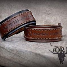 two leather bracelets sitting on top of a stone slab with the words for sale written on them