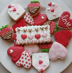 decorated cookies and pastries on a plate with the word love spelled in white letters