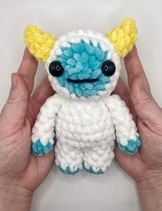 a hand holding a small crocheted stuffed animal