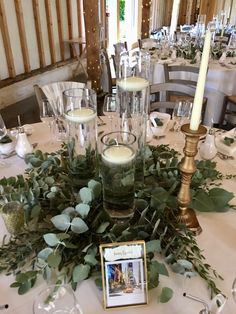 the table is set with candles and greenery