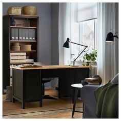 an office desk with a chair, computer monitor and bookshelf in the corner