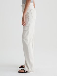 The Gatina wide-leg cargo pants in off-white are a utilitarian-inspired style made from 9.25 oz. Hazy Silk Denim, a soft and luxurious blend of silk, modal, and cotton. This pair features a high-rise waist and long, loose-fitting legs with flap pockets at the sides. Angled hip pockets at the front and squared-off patch pockets at the back. Hazy Silk Denim, 55% Cotton, 35% Modal, 10% Silk Off White Pants, Duster Dress, Cami Midi Dress, Raglan Pullover, Ag Jeans, St Barth, White Pants, Denim Pant, Swimwear Accessories