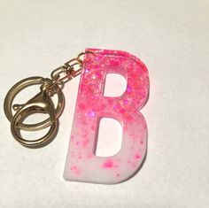 the letter b is painted pink and has glitter on it