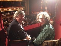 two people sitting in chairs at a theatre